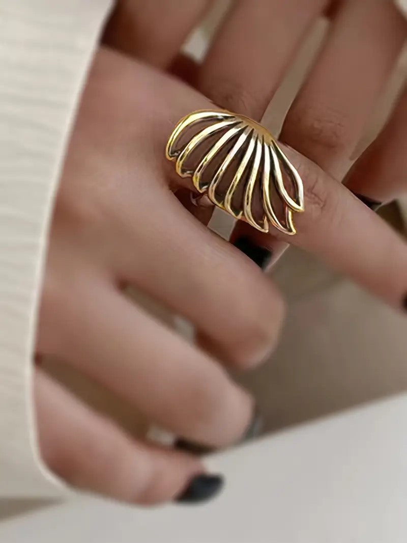 Close-up of Gold Wing Ring with curved, symbolic wing design.