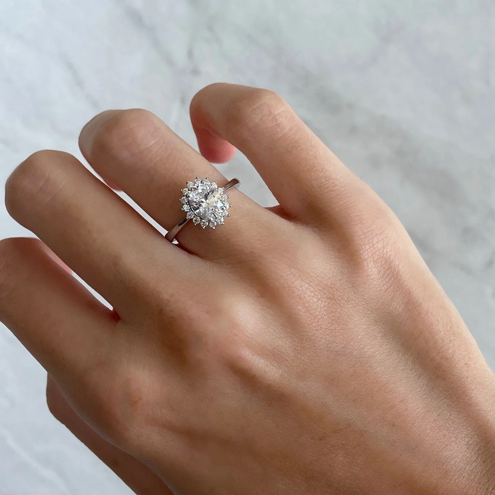 Minimalist rhodium-plated ring with a single round cubic zirconia stone.