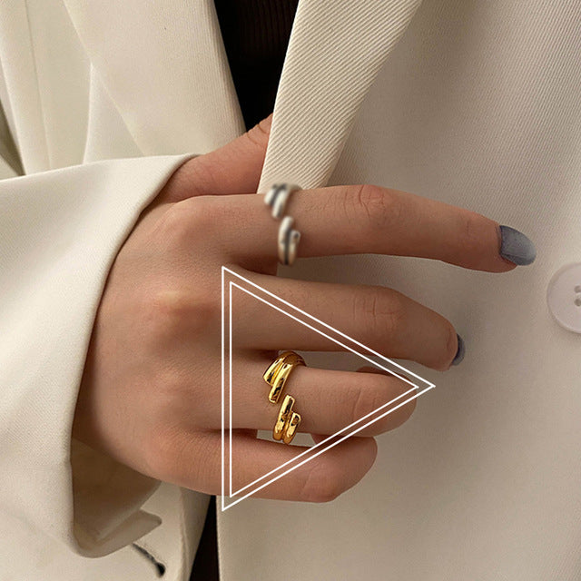 Modern silver ring with intertwined bands and cubic zirconia accents.